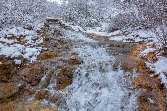 Snow‑covered travertine waterfall rapids in Huanglong Scenic Area, Sichuan, China