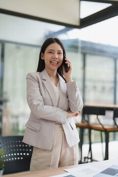 Asian businesswoman communicating on phone with smiling expression