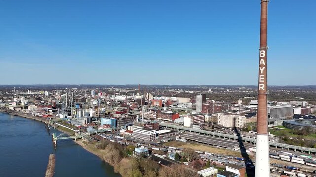 Drone moves from right to left near the Bayer sign and reveals the industrial grounds from a midair perspective.