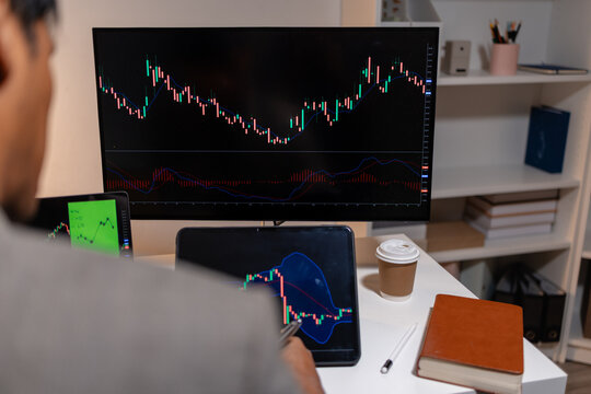 Professional stock trader reviewing market charts with sticky notes across multiple monitors, laptop, and tablet to analyze price trends, plan trading strategies, and manage investment decisions.
