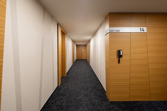 Spacious modern hallway in a hotel with wooden wall paneling and floor directory