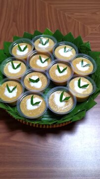 Vertical zoom out reveal of traditional Indonesian Bubur Merah Putih sweet porridge on a bamboo tray