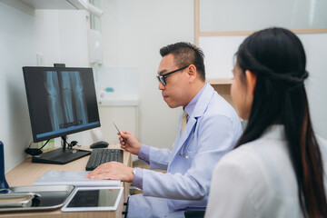 Fototapeta premium An orthopedic doctor explains the patient's bone condition using an X-ray plate, guiding them through the diagnosis and treatment options
