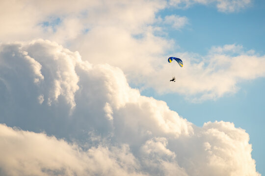 Sportsman flying with motorglider through dark clouds enjoying adrenaline