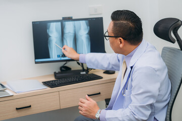Fototapeta premium An orthopedic doctor explains the patient's bone condition using an X-ray plate, guiding them through the diagnosis and treatment options