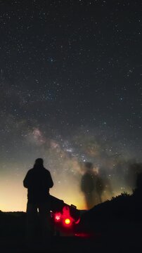 Amateur astronomers observing stars, planets, Moon and other celestial objects with a telescope in nature. Time-lapse video.