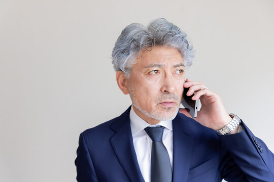 スマートフォンで通話するシニアビジネスマン
