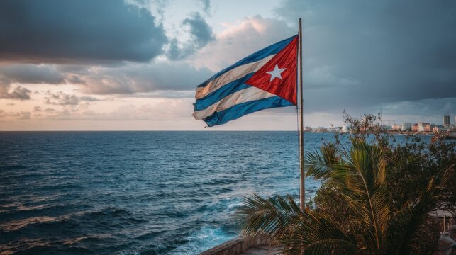Cuban flag waving by the sea during a cloudy evening along the coastline