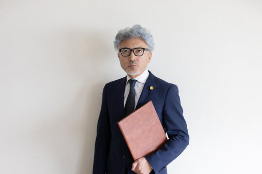 書類ファイルを抱えて立つ弁護士のポートレート
