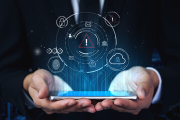 Naklejka premium Hands Holding Smartphone with Digital Security Icons and Warning Symbol Representing Cybersecurity Risks in Modern Technology. Entropy.