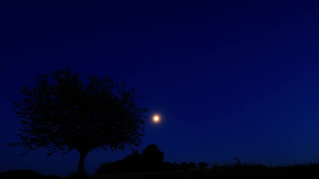 Moon on a twilight sky with stars, planets and landscape mountain silhouettes.