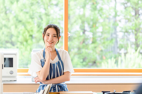 キッチンで考える女性。料理、レシピ、献立、栄養士、笑顔、期待、楽しみ、家事、主婦、アイデア、掃除