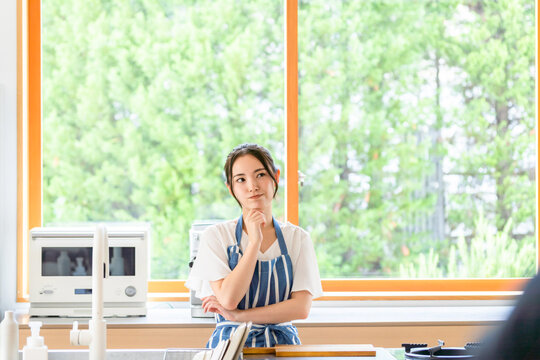 キッチンで考える女性。料理、レシピ、献立、栄養士、悩み、疑問、不安、心配、不満、家事、主婦、困る