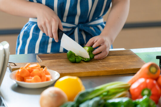Woman cutting vegetables in the kitchen while cooking