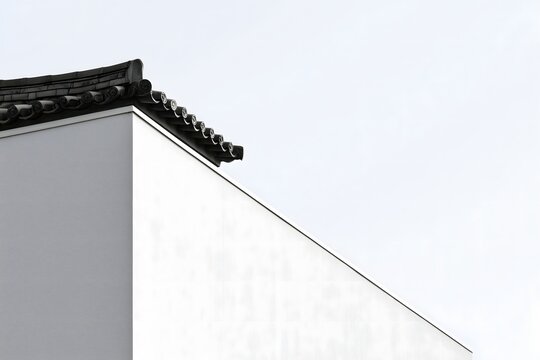 High-key architectural photography of white wall and traditional Asian roof edge