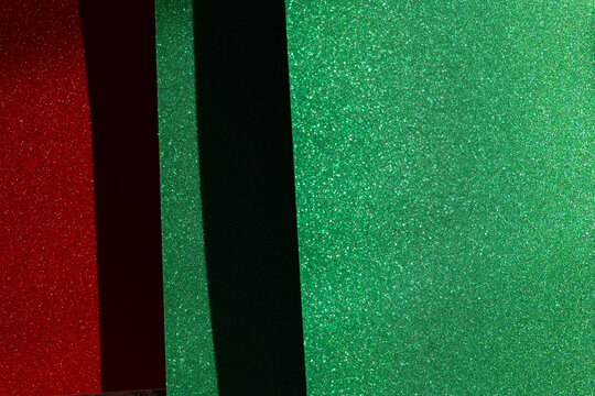 Sparkling red panel framed by green glitter surfaces and a dark divider, providing copy space for Christmas sales, discount announcements, coupons, retail banners and holiday promotions.