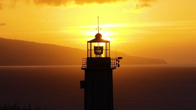 Farol Do Cintra Lighthouse During A Sunset With Vibrant Orange Sky And Calm Sea In Sao Miguel Island, Azores. Portugal. - aerial shot