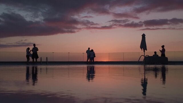 People Silhouettes by Infinity Pool at Sunset in Puerto Naos