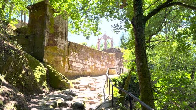 Woodland path approaches San Pedro de Rocas bell gable in Esgos, Ourense, Galicia, Spain