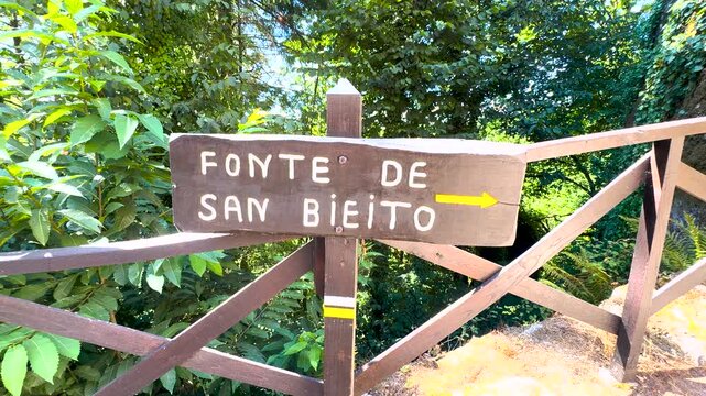 Wooden sign identifies Fonte San Benito in forest at Esgos, Ourense, Galicia, Spain