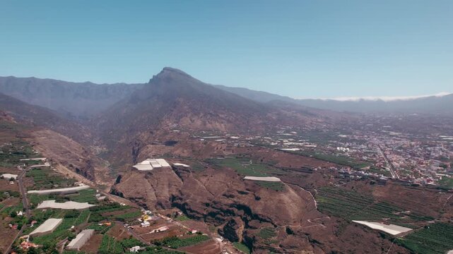 A sweeping aerial reveal moves from terraced farmland into a wide panorama of the western coastline.