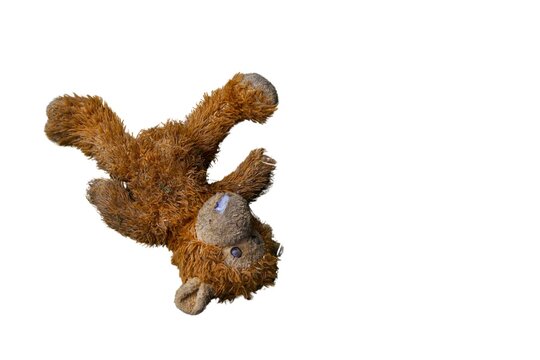 Old dirty plush monkey toy isolated on a white background