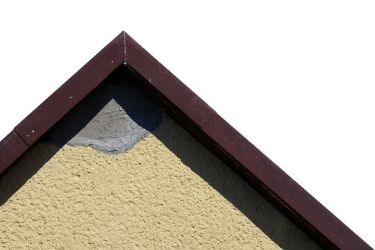 House gable peak with yellow plaster and unpainted grey cement patch isolated on a white background