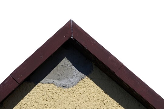 House gable peak with yellow plaster and unpainted grey cement patch isolated on a white background