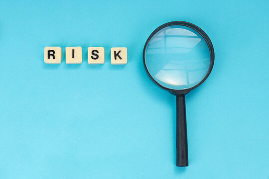 Business Risk Inspection and Data Security Evaluation with Magnifying Glass Over Blue Background