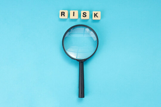Flat Lay of Risk Letter Blocks and Magnifying Glass for Financial Audit