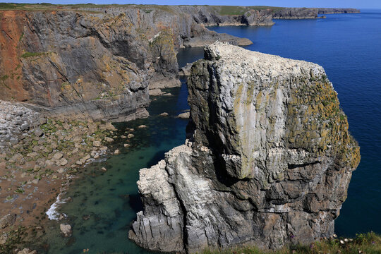 Landscape photo with a view of the rocky coastline and a single cliff Elegug Stacks near Pembroke, Wales, UK	