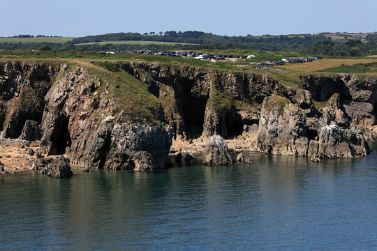 Landscape photo with a view of a bay, rocky coastline and beaches surrounded by mountains on St Govan's Head near Pembroke, Wales, UK	