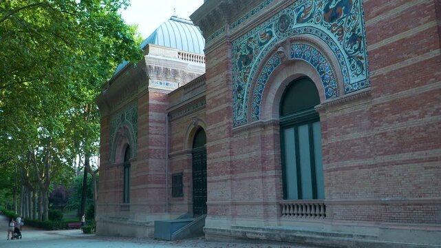 Exterior of the historic Velazquez Palace featuring intricate ceramic tilework and brick architecture in Retiro Park, Madrid. Authentic travel and heritage concept.