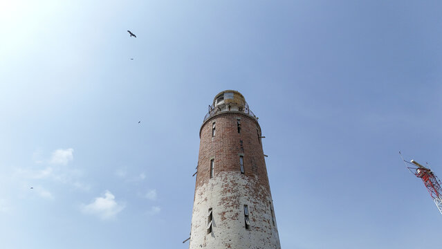 Aerial view of the historic brick lighthouse at Tarkwa Bay Beach against a clear blue sky in Lagos, Lagos, Nigeria.
