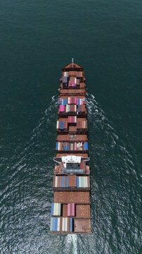 Aerial view of a large container ship loaded with colorful shipping containers navigating the deep blue waters of the Atlantic Ocean near Lagos, Lagos, Nigeria.