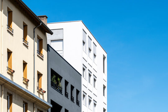 Residential apartment architecture in Paris France with modern and older facades beneath a vivid blue sky creating a spacious layered urban housing scene