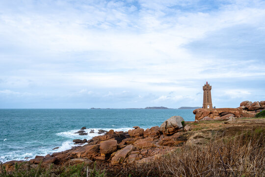 Mean Ruz lighthouse rising above granite shore in Tregastel, Brittany, France