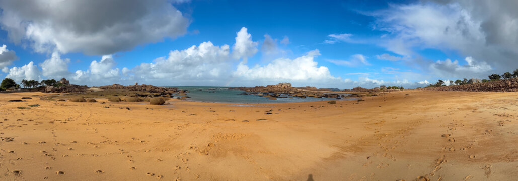 Rocky tidal island under bright skies in Tregastel, Brittany, France. Panoramic view