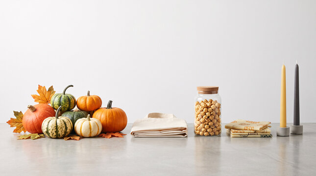 Nature morte automnale avec citrouilles, pois chiches, bougies et linge