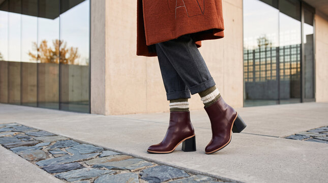 Bottines bordeaux port&eacute;es avec un pantalon d&rsquo;automne en milieu urbain