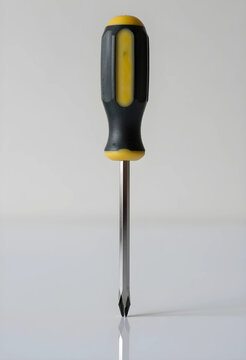 Repair and maintenance tools, single phillips head screwdriver with yellow and black handle, isolated on a white background