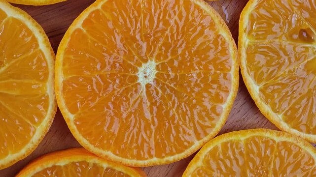Sliced orange on wooden plate.