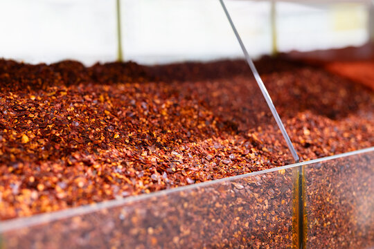Crushed red chili flakes displayed in bulk at an oriental bazaar in Bukhara, Uzbekistan. Close-up view highlighting the texture and abundance of dried pepper at a spice market stall.