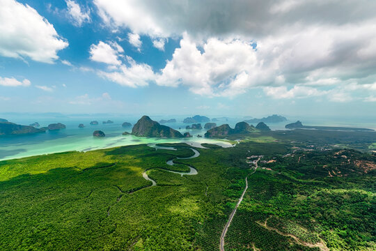 Panoramic view from above of rivers, mangrove forests in the mouths of the bay against the backdrop of high cliffs in the distance in Southeast Asia