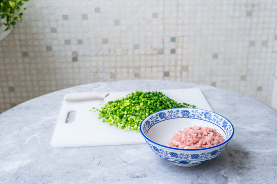 Dumpling filling ingredients&mdash;chopped chives and ground pork.