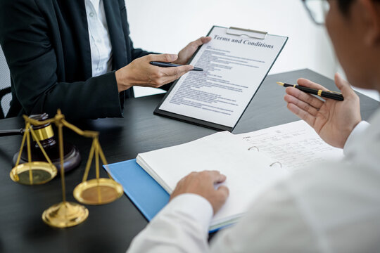 Female lawyer is pointing on legal document to explaining about