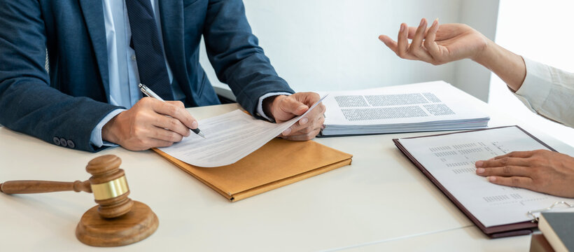Male lawyer is pointing on legal document to explaining about co