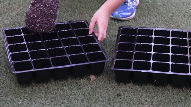 連結ポットに培養土を入れる子供たち
