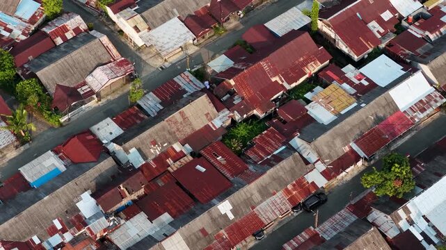 Drone captures rows of traditional houses along narrow roads during a bright sunny afternoon