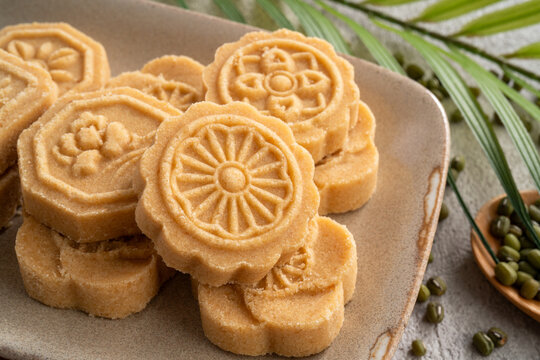 Traditional Chinese peanut mung bean cake with floral patterns on a ceramic plate.